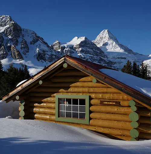 Snow-covered cabin with mountain views