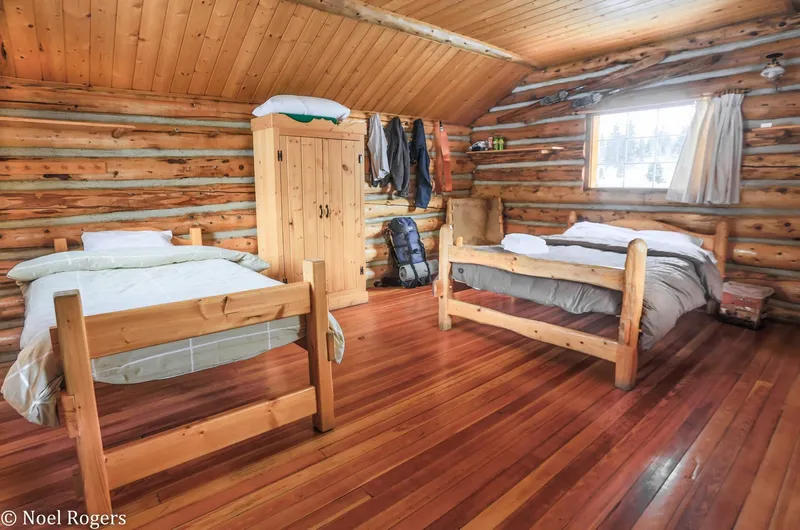 Cabin interior with two beds and log walls