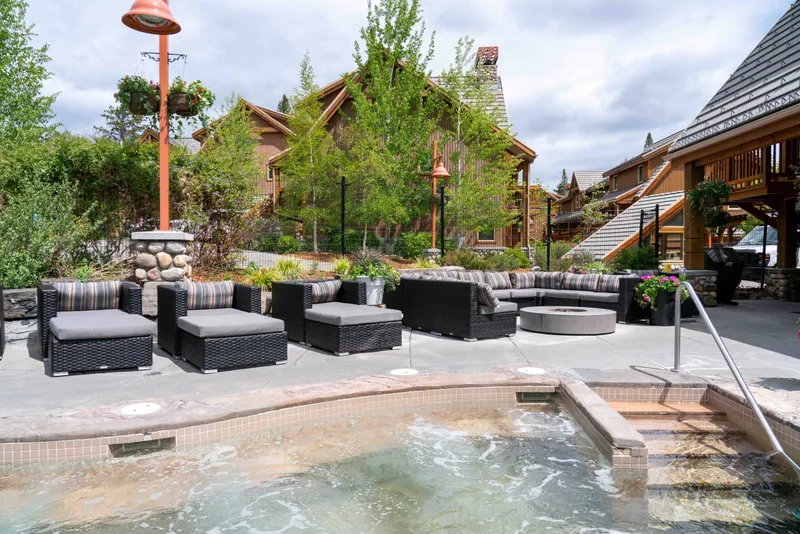 Hidden Ridge Resort's outdoor pool terrace with heated water, lounge seating, and timber lodge buildings.